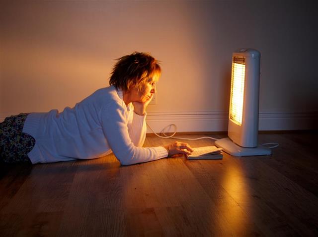 Mature woman reading by glow of halogen lamp