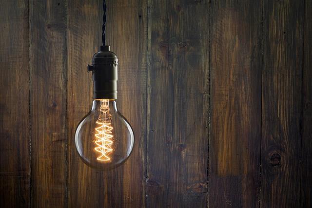 Vintage incandescent Edison type bulb on wooden background