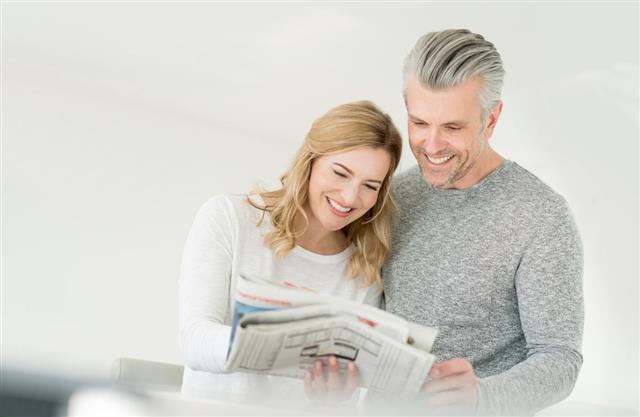 Couple looking in newspaper