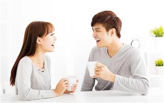 Happy young Couple drinking coffee In living room