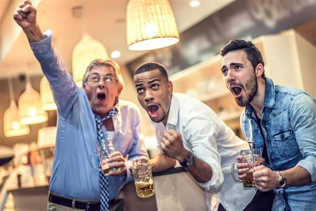 Friends celebrating their team scoring in a bar