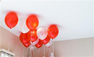 Red and white balloons floating in the room