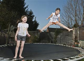 Girls jumping together on trampoline