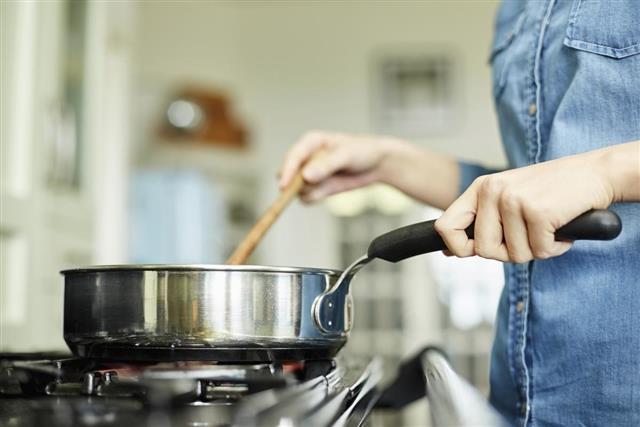Midsection image of woman cooking food in pan