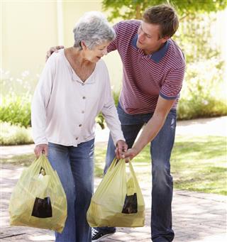Man Helping Senior Woman With Shopping