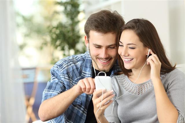 Couple sharing music from smart phone