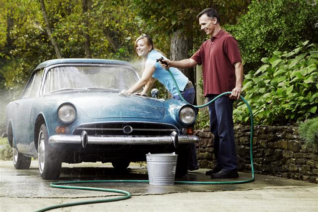 Couple Washing Vintage Car