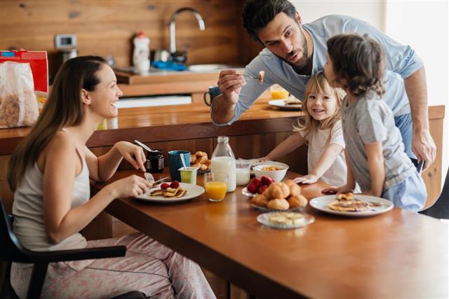 Photo of a young happy family having breakfast