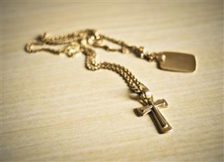 Gold Crucifix Necklace On A Table