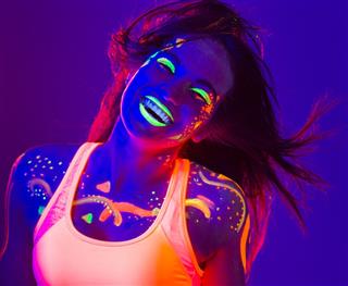 Happy Young women covered with uv color dancing