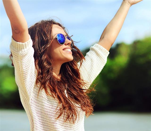 Attractive happy woman in sunglasses enjoying freedom outdoors