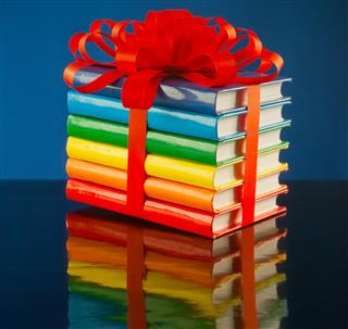 Stack of colorful books tied up with red ribbon