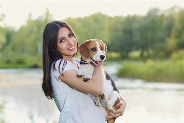 Portrait of a teenage girl with her dog outdoors.