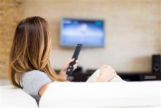Young woman on couch watching TV