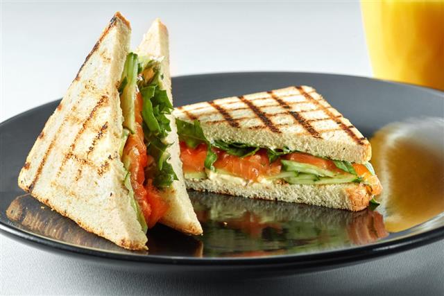 Sandwich with salmon and orange juice for breakfast