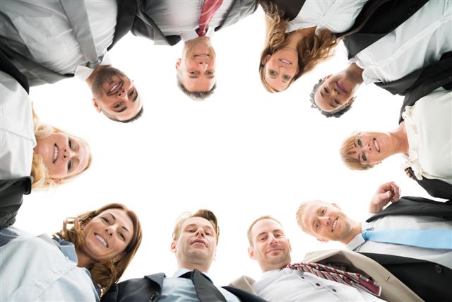 Portrait Of Confident Business Team Standing In Huddle