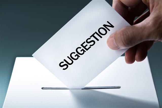 Hand Inserting Suggestion into Suggestion Box