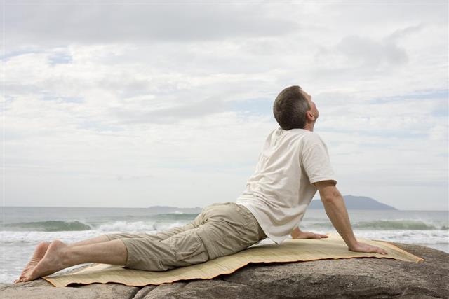 Mature Man Doing Yoga at Sea