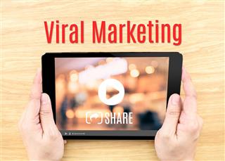 Hand holding tablet with Viral marketing word