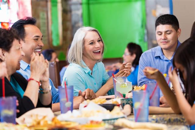 Friends laughing over dinner in casual Tex-Mex restaurant