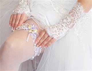 Bride corrects garter on her leg