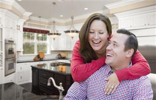 Happy Laughing Couple In Beautiful New Kitchen