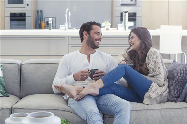 Couple drinking coffee on the sofa