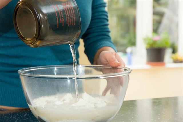 Adding water to a mixing bowl