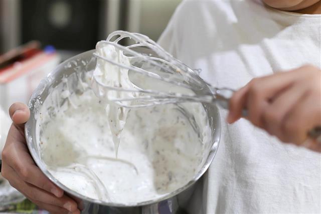 Young boy mixing flour with whisk