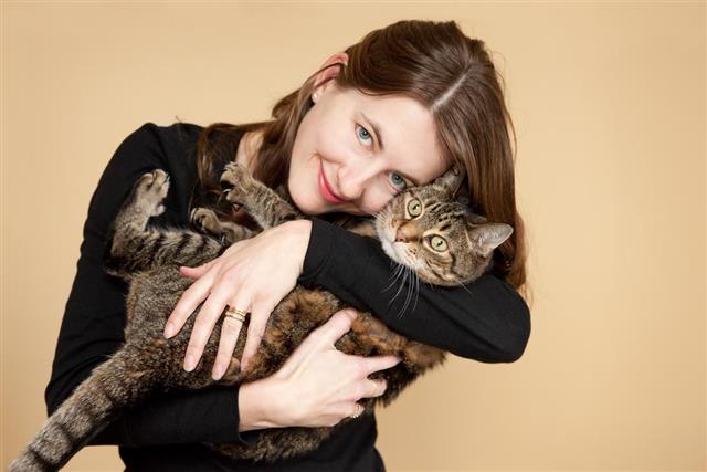 Smiling Woman Hugging Her Tabby Cat