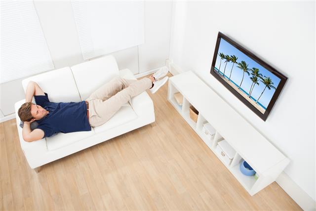 Man Watching Beach View On TV At Home