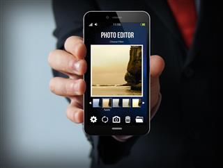 Businessman with photo editor smartphone