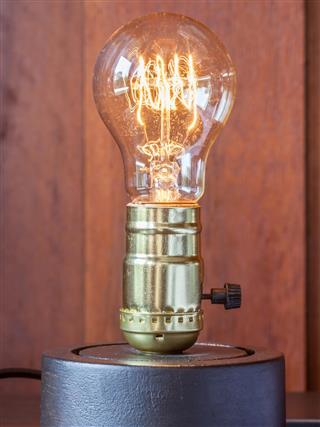 Vintage Edison light bulb with wood background for hotel decoration.