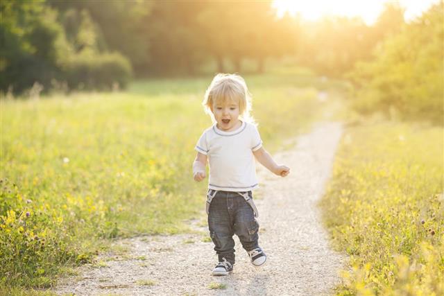 Happy little boy running outside