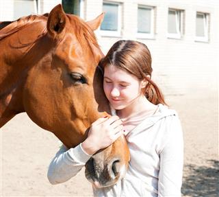 Teenage Girl Hugging her Horse