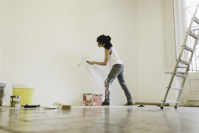 Young woman painting her new apartment