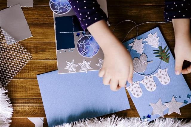 Little girl making Christmas cards