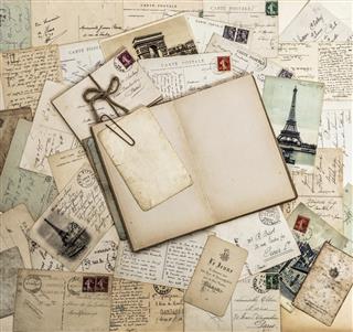 Open book, old letters and postcards. Travel scrapbook France Paris