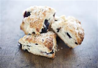 Four Blueberry scone pastries on a wooden table