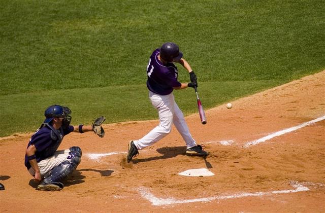 Baseball Swing as batter hits a pitched ball