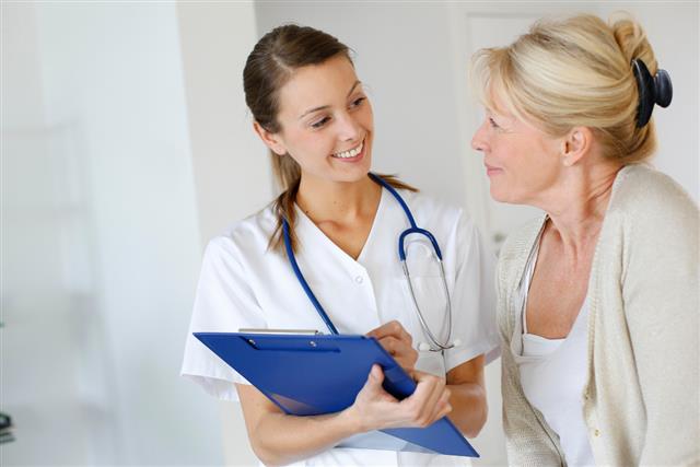 Young doctor smiling and talking to older patient