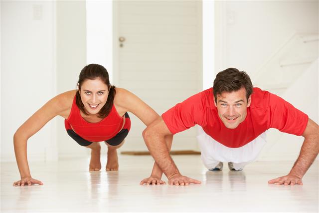 Couple doing push-ups in home