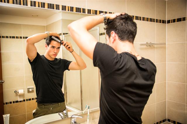 Reflection of Man Bushing Hair in Mirror