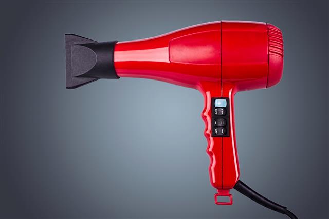 red hair dryer in gray background