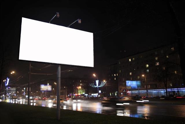 Photo of a nighttime city scene, and a blank white billboard