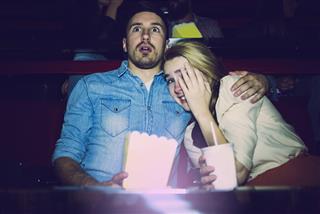 Couple watching a horror movie in the cinema