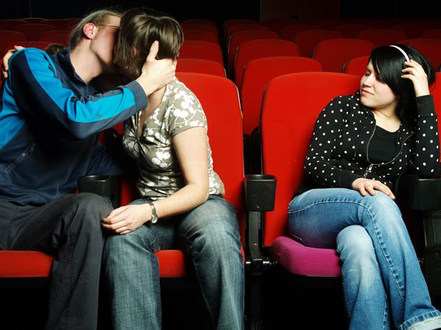 Couple kissing at movie theater