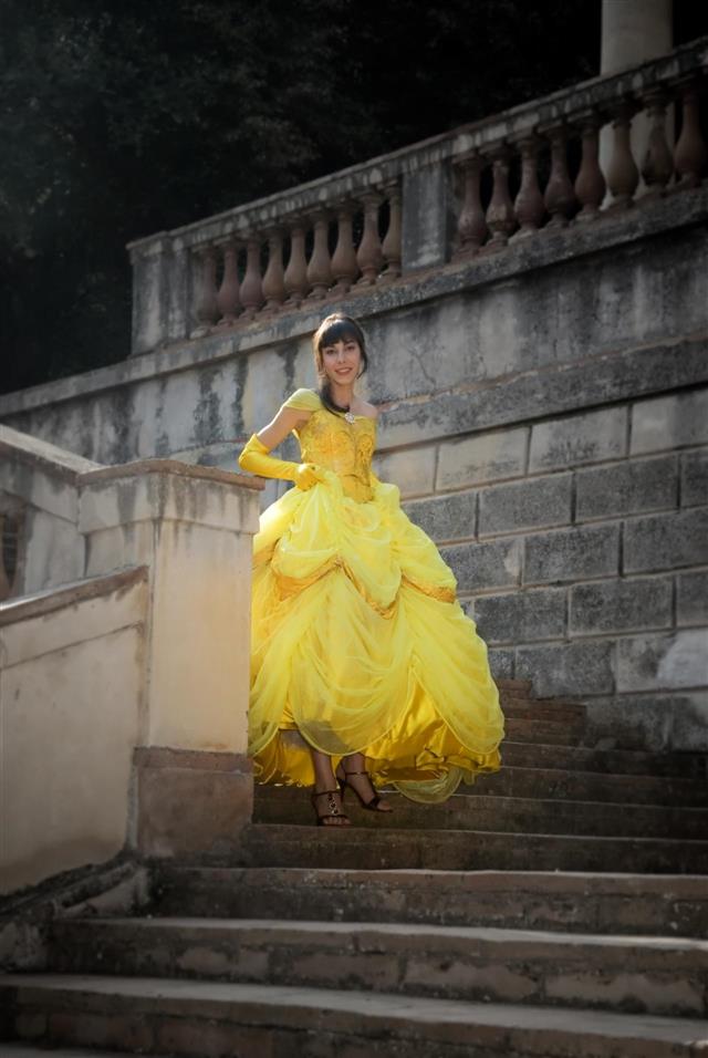 a girl with a yellow dress on walking down the stairs