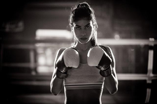 Young woman boxer ready to fight in the boxing ring