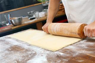 Baker Rolls Dough For Croissants